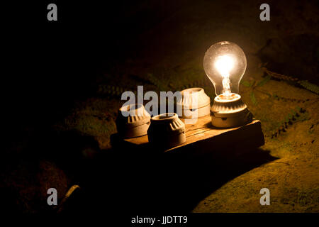 eine Glühbirne von vier anderen. Eine Metapher für die richtige Entscheidung. Stockfoto