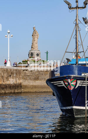 Angeln, Hafen und Statue der Virgen del Carmen in der Mole am unteren Rand der Ortschaft Santurtzi, Bilbao, Vizcaya, Baskenland, Spanien Stockfoto