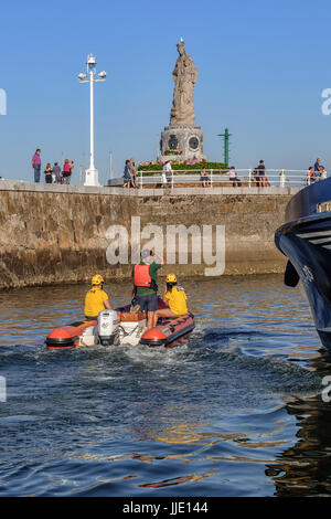 Angeln, Hafen und Statue der Virgen del Carmen in der Mole am unteren Rand der Ortschaft Santurtzi, Bilbao, Vizcaya, Baskenland, Spanien Stockfoto