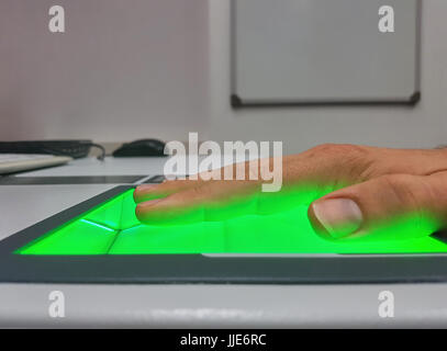 Seitliche Ansicht von einem Mann mit einem Fingerabdruck-Scanner für Identifikation. Biometrie oder Cyber-Sicherheit-Konzepte. Stockfoto