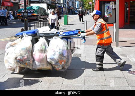 Behälter Säcke & Beutel voller Müll Müll Müll Hand karre in der Einkaufsstraße von Rat-Arbeiter von Seaside Resort Pflaster Behälter gesammelt geschoben Stockfoto