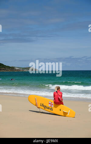 junge weibliche Rettungsschwimmer Ausblick auf das Meer am Strand von Carbis Bay in der Nähe von St. Ives, Cornwall Stockfoto