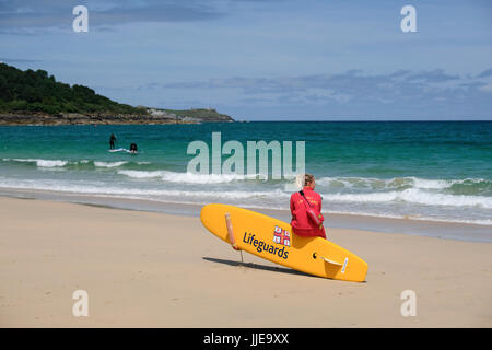 junge weibliche Rettungsschwimmer Ausblick auf das Meer am Strand von Carbis Bay in der Nähe von St. Ives, Cornwall Stockfoto