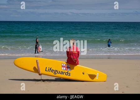 junge weibliche Rettungsschwimmer Ausblick auf das Meer am Strand von Carbis Bay in der Nähe von St. Ives, Cornwall Stockfoto