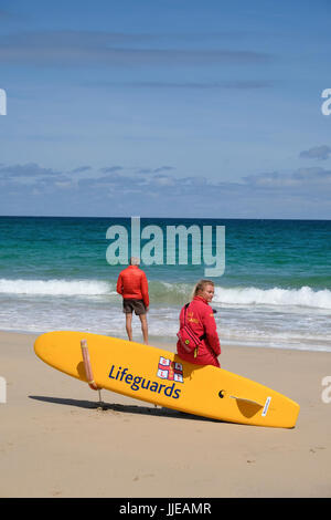 junge weibliche Rettungsschwimmer Ausblick auf das Meer am Strand von Carbis Bay in der Nähe von St. Ives, Cornwall Stockfoto