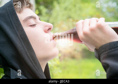 junger Mann mit Kapuze eine Cola zu trinken Stockfoto