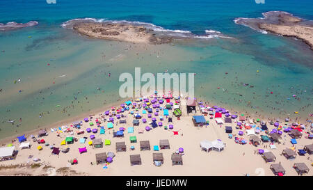 Tropischer Strand mit bunten Sonnenschirmen - Top-down-Luftbild Stockfoto