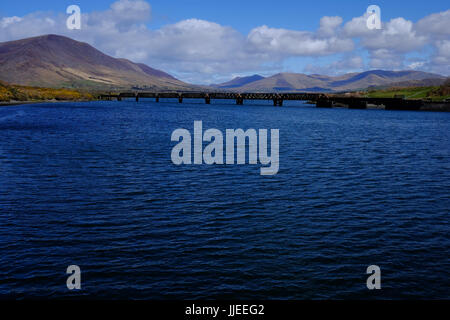 Der Fluss Fertha und die stillgelegten Eisenbahnbrücke vor den Bergen in Cahirsiveen, County Kerry, Irland Stockfoto