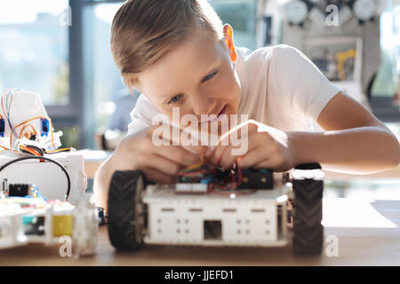 Liebenswert Kind Drähte in Roboterfahrzeug Befestigung Stockfoto