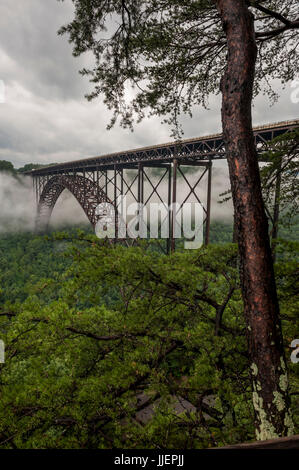 Nebel-Wirbel um die Brücke über den New River Gorge und New River, in den Appalachen in der Nähe von Fayetteville, WV.  Die Brücke, Baujahr 1977, ist die größte Spannweite Stahlbrücke in der westlichen Hemisphäre und die dritte höchste in den USA.  Es erstreckt sich über den New River National River, Bestandteil der US-Park-Service. Stockfoto