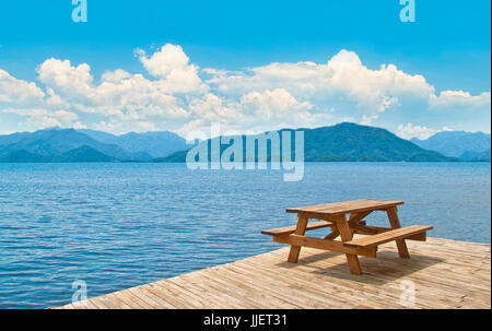 Holztisch mit Bänken auf Plattform mit Blick auf das Ägäische Meer und die Inseln in der Nähe von Marmaris, Türkei an sonnigen Tag Stockfoto