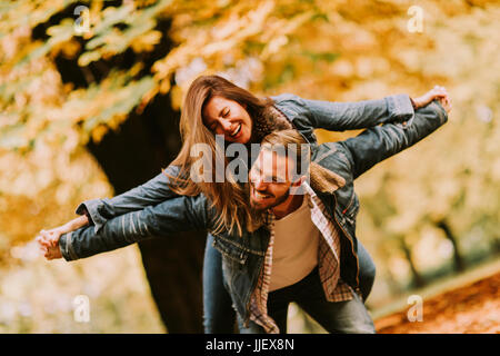 Junges Paar, das Spaß im Herbst Park an einem sonnigen Tag Stockfoto