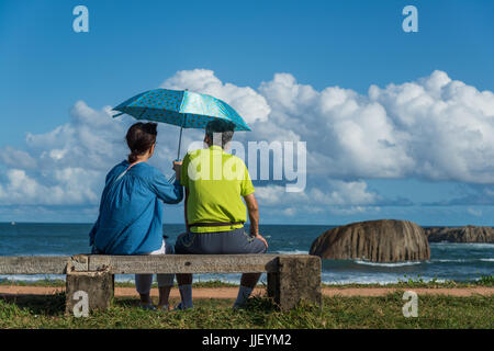 Paar, sitzen auf einer Bank mit einem Regenschirm, Galle, Sri Lanka Stockfoto