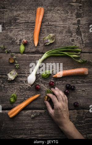 Zarte Frauenhand mit Obst und Gemüse Stockfoto