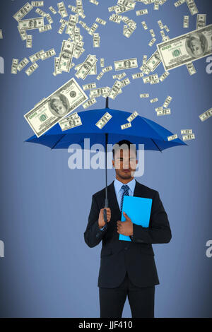 Porträt von Ernst Kaufmann holding blaue Regenschirm und Datei vor grauem Hintergrund Stockfoto