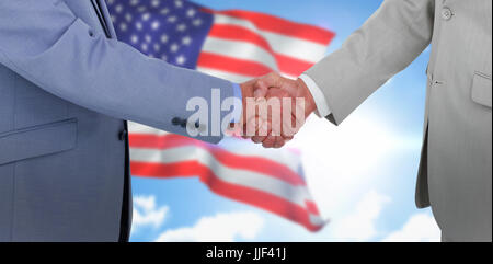 Seitenansicht des Händeschütteln gegen zusammengesetztes Bild der Nahaufnahme von den USA Flagge Stockfoto