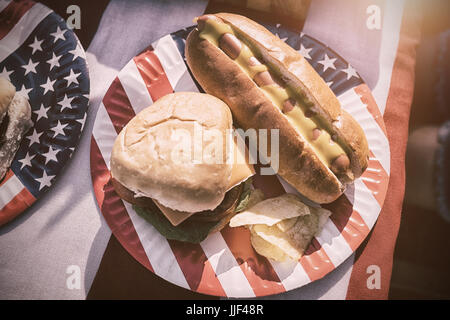 Amerikanische Mittagessen mit Hot Dog und Burger auf eine amerikanische tableclothe Stockfoto