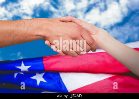 Mann und Frau tun Handshake gegen Blick auf schönen Himmel und Wolken Stockfoto