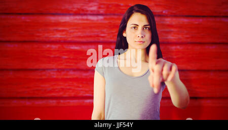 Portrait von junge Frau zeigte gegen full-Frame-Schuss der roten Wand Stockfoto