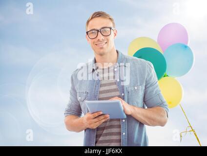 Digitalen Verbund von Mann mit Tablette gegen sonnigen Himmel und Luftballons mit Fackel Stockfoto