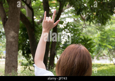 Weibliche Hand mit ich liebe dich finger-Geste. Frau, die Symbol-Zeichen-Sprache im park Stockfoto