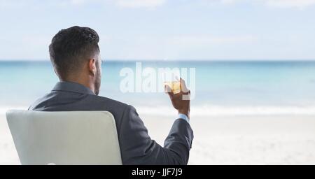 Digital Composite Geschäftsmann wieder im Stuhl sitzen trinken Glas und Meer Stockfoto