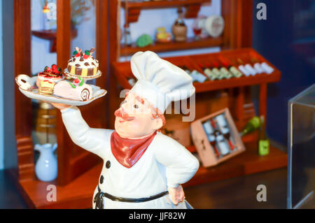 Bildnis von einem Chefkoch mit einem Tablett von Kuchen in einem Restaurant im Schwarzwald Stockfoto