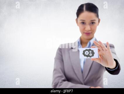 Digital Composite Business Frau mit Karte zeigt graue Wolke und Getriebe Grafik gegen weiße Wand Stockfoto