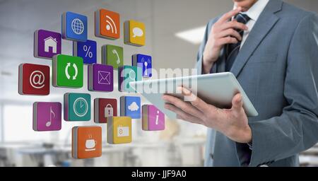 Digital Composite Geschäftsmann Holding Tablette mit apps Icons im Tagungsbüro Fabrik Stockfoto