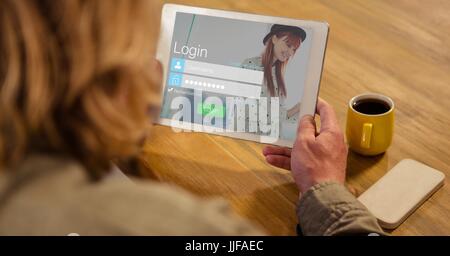 Digitalen Verbund der Rückansicht der Frau betrachten Login-Bildschirm auf digitalen Laptop mit Smartphone und eine Tasse Tee Stockfoto