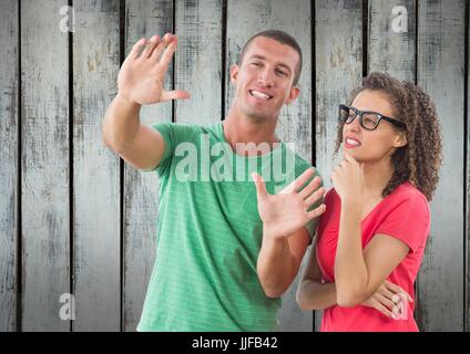 Digitalen Verbund eines Mannes zeigt etwas mit einer Mädchen vor Holz Wand Stockfoto