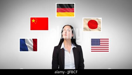 Digitalen Verbund aus Geschäftsfrau von Flaggen vor grauem Hintergrund stehend Stockfoto