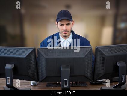 Digital Composite Wachmann suchen die Bildschirme in einem unscharfen Office-Hintergrund Stockfoto