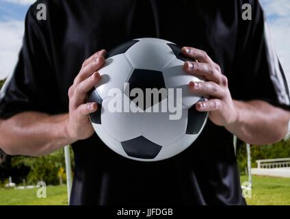 Digitalen Verbund aus Fußball-Spieler mit Ball in seinen Händen, Feld Hintergrund Stockfoto