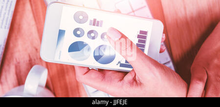 Blaue Symbole auf weißem Hintergrund gegen Geschäftsfrau mit ihrem Smartphone auf Schreibtisch Stockfoto