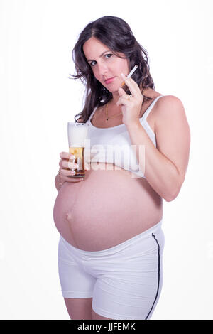 Schwangere Frau mit einer Zigarette in einer Hand und einem Baso Bier in der anderen Stockfoto