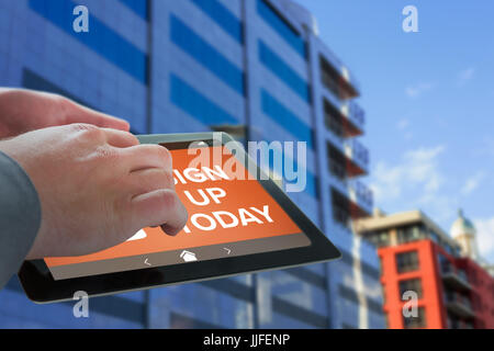 Geschäftsmann berühren Tablet-Bildschirm gegen Reflexion über Glasbau Stockfoto