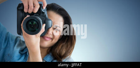 Junge Frau fotografieren durch Kamera gegen lila vignette Stockfoto