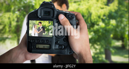 Zusammengesetztes Bild der freigestellten Bild von Händen mit Kamera Stockfoto
