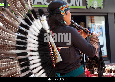 Reading, UK - 17. Juni 2017:Native südamerikanischen Flötenspieler in traditioneller Tracht mit Federn als Straßenmusikant in einer englischen Stadt Stockfoto