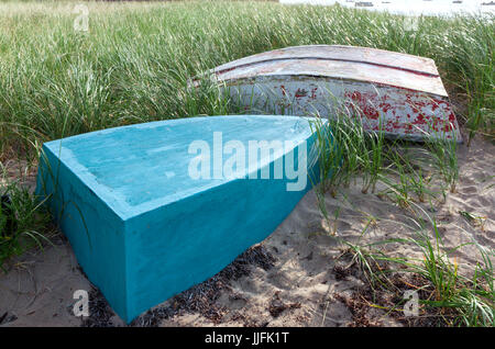 Boote (eine langsame und eine Dory) in den Sand und Rasen am Strand auf Cape Cod. Stockfoto