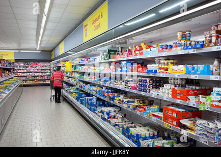 Kunden mit einem Wagen in die gekühlte Milchprodukte von Netto Marken-Discount Supermarkt einkaufen. Stockfoto