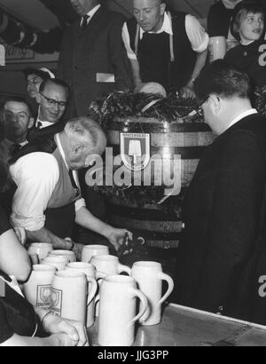 Ehemaliger Bürgermeister Thomas Wimmer tippt den ersten Lauf auf dem Oktoberfest (September 1960). Sein Nachfolger im Amt, Bürgermeister Dr. Hans-Jochen Vogel, schaut ihm zu lernen, wie man den Lauf im Folgejahr zu tippen. | weltweite Nutzung Stockfoto