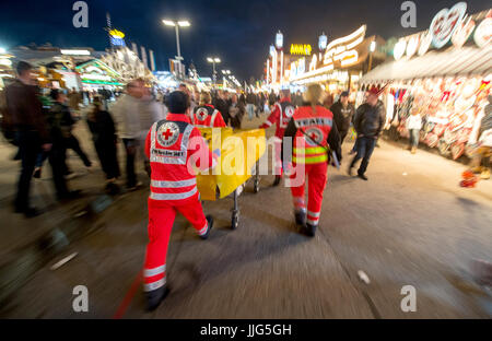 Sanitäter des Deutschen Roten Kreuzes drücken eine Bahre an einen Speicherort auf dem 182. Oktoberfest in München, 23. September 2015. 8.000 Patienten behandelt wurden, in der erste-Hilfe-Station laufen durch das Deutsche Rote Kreuz im vergangenen Jahr mit 680 von ihnen leiden an Alkoholvergiftung. Die weltweit größte Bier-Festival, 4. Oktober 2015 abgeschlossen wird, wird voraussichtlich rund 6 Millionen Besucher aus aller Welt in diesem Jahr gewinnen. Foto: MATTHIAS BALK/Dpa | weltweite Nutzung Stockfoto