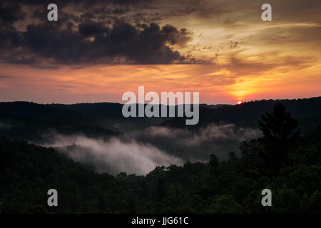 Die Sonne scheint über den Wald Bergen in den Appalachen, aus dem Blickwinkel eines natürlichen Sandstein Bogen. Stockfoto