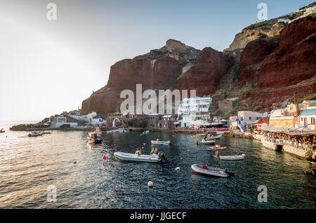 Amoudi, Santorin, Griechenland. Amoudi Bay befindet sich unter Dorf Oia. Boote und Tavernen in der Nähe des Wassers. Stockfoto