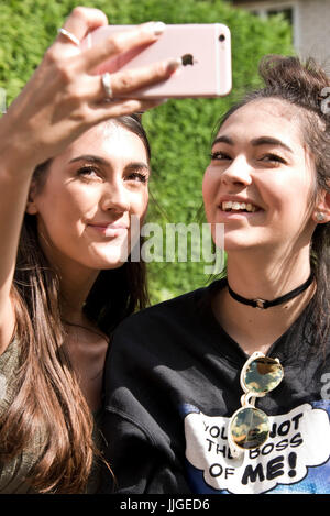 Vertikale Porträt von zwei Mädchen, die die Selfies auf ihrem Handy. Stockfoto