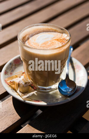 Vertikale Nahaufnahme von einem Glas heißen Kaffee in der Sonne. Stockfoto