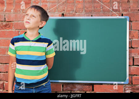 Meditative junge in der Nähe von Tafel mit textfreiraum in der improvisierten Outdoor-Klasse Stockfoto