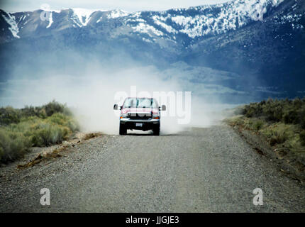 Ein Ford Pickup fahren über eine Schotterstraße mit wehenden Staub hinter sich. Stockfoto